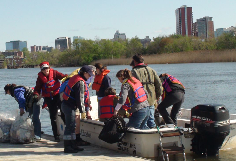Image: A photo of Volunteers at an earlier Christina River Cleanup offloading trash and debris collected during the event