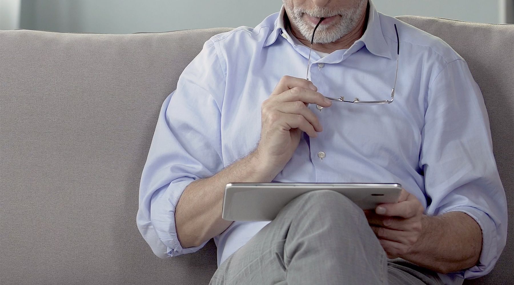 Image of a man looking at news on an iPad.
